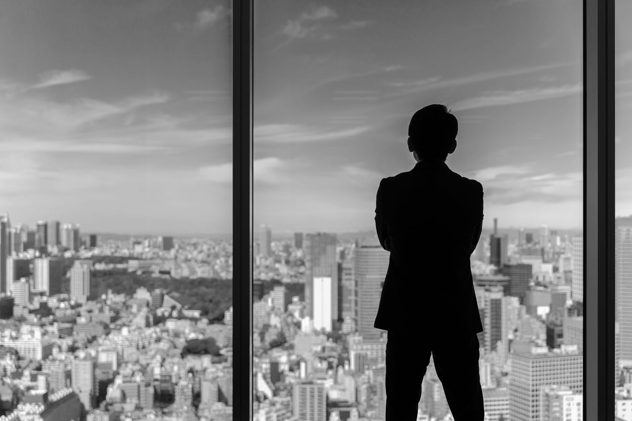 businessman wearing suit looking cityscape of tokyo