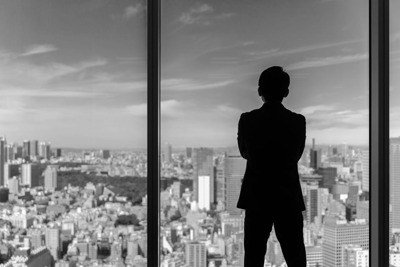 businessman wearing suit looking cityscape of tokyo